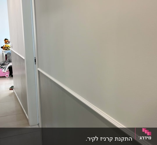 מסדרון עם קירות לבנים ורצפת פרקט בהירה